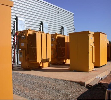 Several large electrical boxes on a cement platform.